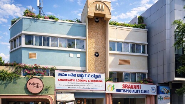 Rakennuksessa on kyltti, jossa lukee Amaravathi Lodging & Boarding, ja siellä toimii myös Baker's Miller -niminen leipomo sekä Sravani Multispeciality Clinic -niminen klinikka.