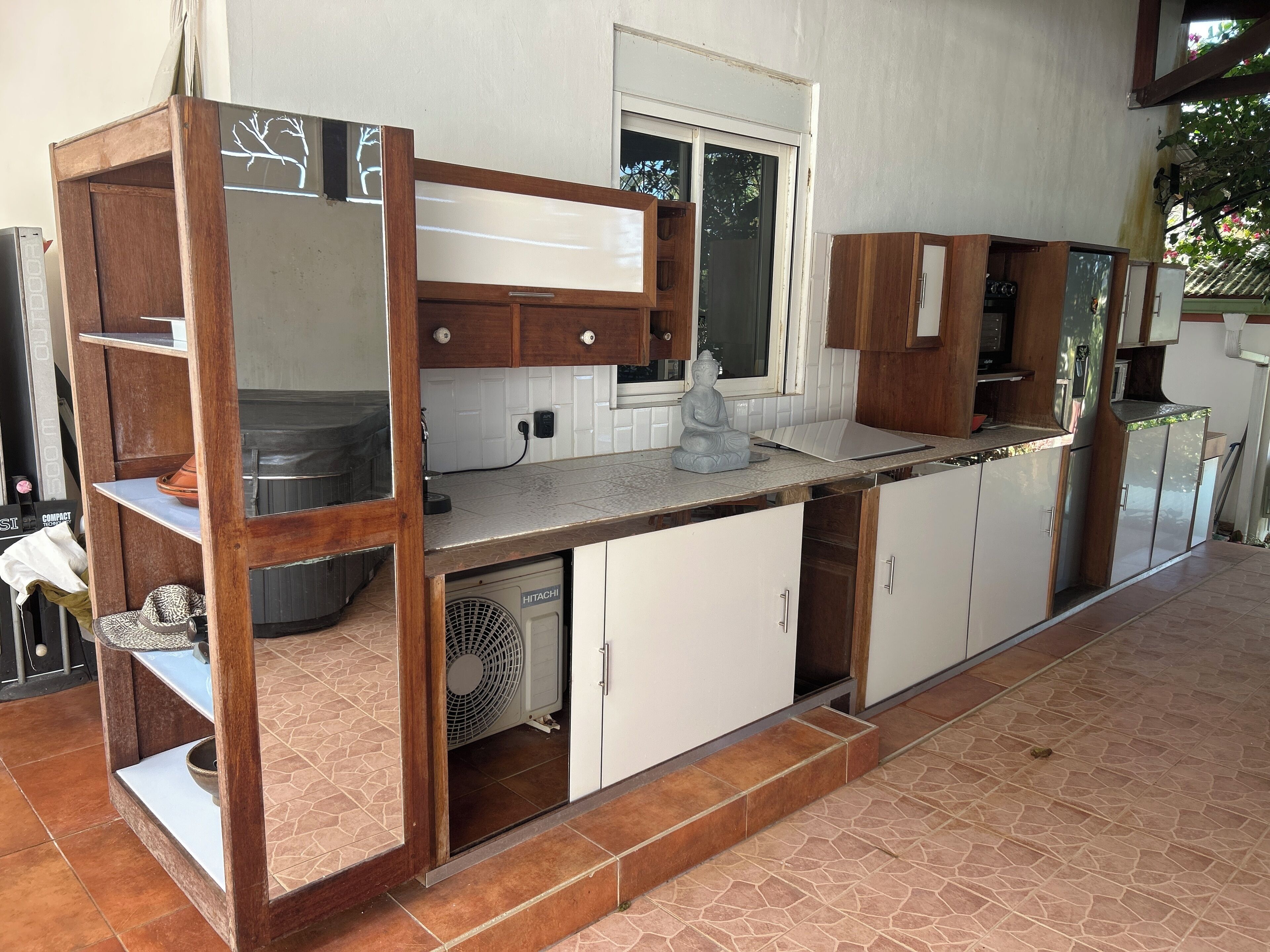 A kitchen with a built-in stove, white cabinets, and a fan.