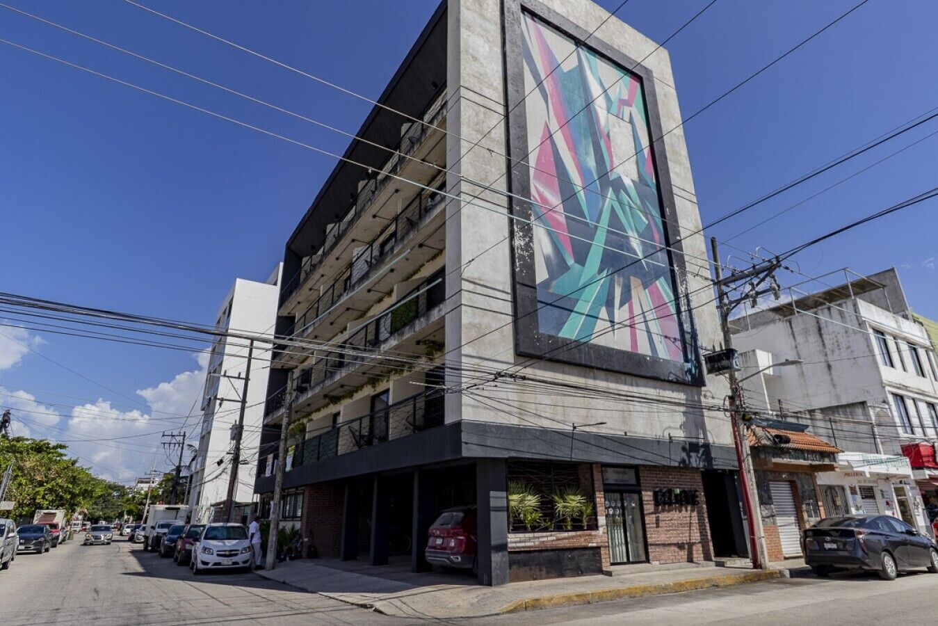 Um edifício de vários andares com um mural grande e colorido na fachada.