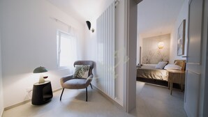 Ein modernes Schlafzimmer mit Bett, Nachttisch und einem Sessel.