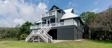 A two-story house with a balcony, a garage, and a staircase leading to the upper level.