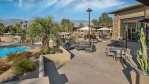 A poolside area with lounge chairs, a table, and umbrellas. -  2 Prem. condos in Palm Desert week of 3/1/27 - 1st week of BNP Paribas Tourney (Palm Desert)