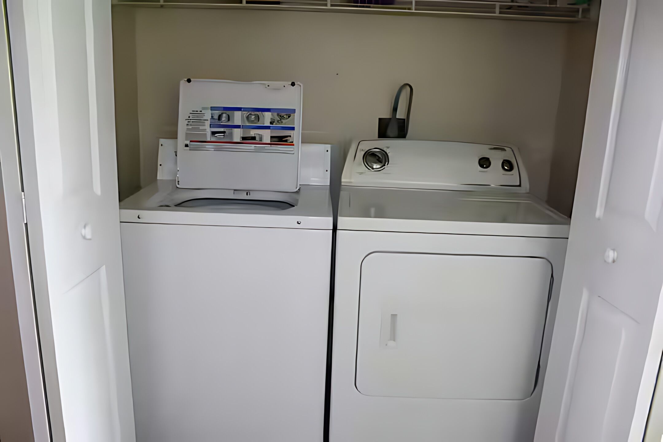 A compact laundry area with a front-loading washer and a stacked dryer.