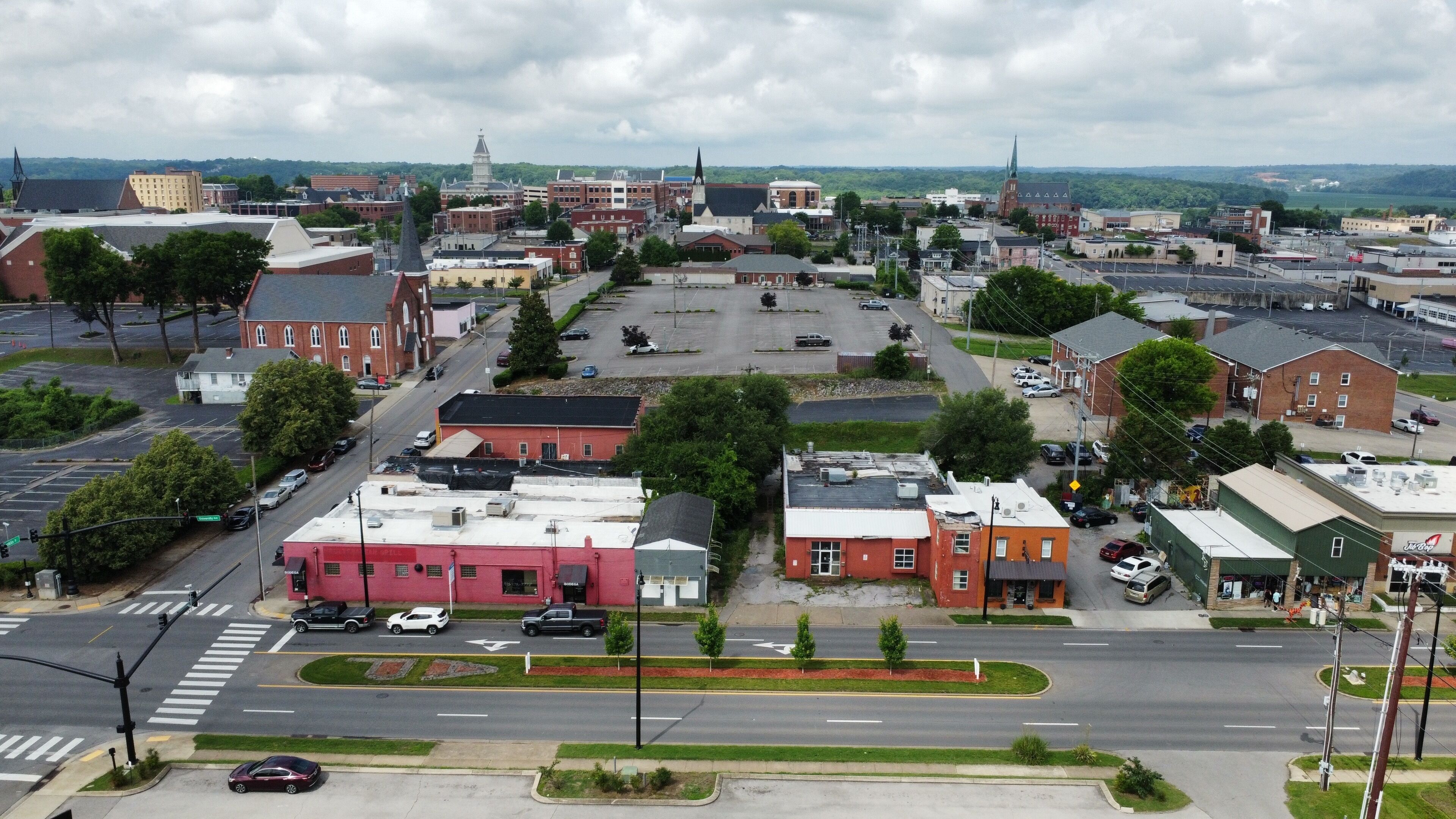 A town with a mix of commercial and residential buildings, a central roundabout, and a church with a steeple.