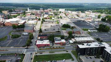 Une vue aérienne d’une ville avec différents bâtiments, des rues et des zones de stationnement.