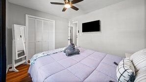 A bedroom with a bed, a ceiling fan, a TV, and a wardrobe. - Enjoy Our 936sf Single-story Home With a Private Entrance (Clarksville)