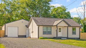 A single-story house with a garage, a front porch, and a driveway. - Enjoy Our 936sf Single-story Home With a Private Entrance (Clarksville)