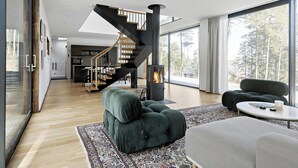 A modern interior with a staircase, a fireplace, and large windows. - Airy house with large glass fronts on Adelsö (Adelsö)