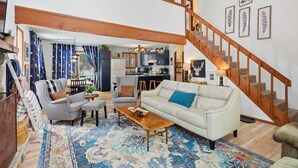 A spacious living area with a sofa, armchairs, a coffee table, and a staircase. - Pocono Lake House - Short Walk to All Amenities! (Albrightsville)