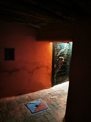 A narrow corridor with a red wall and a metal door with decorative elements. - Tremendous 3-Private bedroom  riad in Marrakech perfect for your getaway (Marrakech)