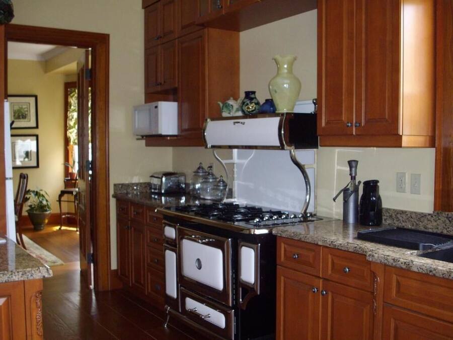 A kitchen with wooden cabinets, a stove, a microwave, and a coffee maker.