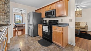 A kitchen with a refrigerator, microwave, stove, and a pool table. - Cozy Family Retreat Near Fort Campbell, Sleeps 8 (Clarksville)