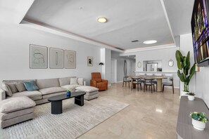 Ein modernes Wohnzimmer mit einer Couch, einem Couchtisch und einem Essbereich mit Stühlen und einem Tisch.