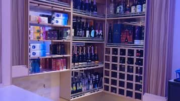 Un bar bien organisé, doté de plusieurs étagères et contenant une variété de bouteilles.