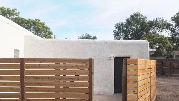 A white building with a wooden gate and a door. - Downtown District - Modern Apt Yard, King Bed, W/D (Albuquerque)
