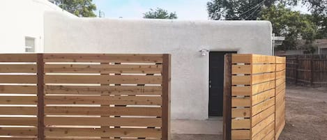 A white building with a wooden gate and a door.