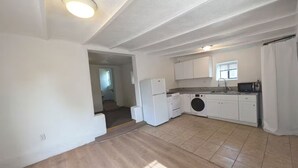 A kitchen with white cabinets, a washing machine, and a microwave. - Downtown District - Modern Apt Yard, King Bed, W/D (Albuquerque)