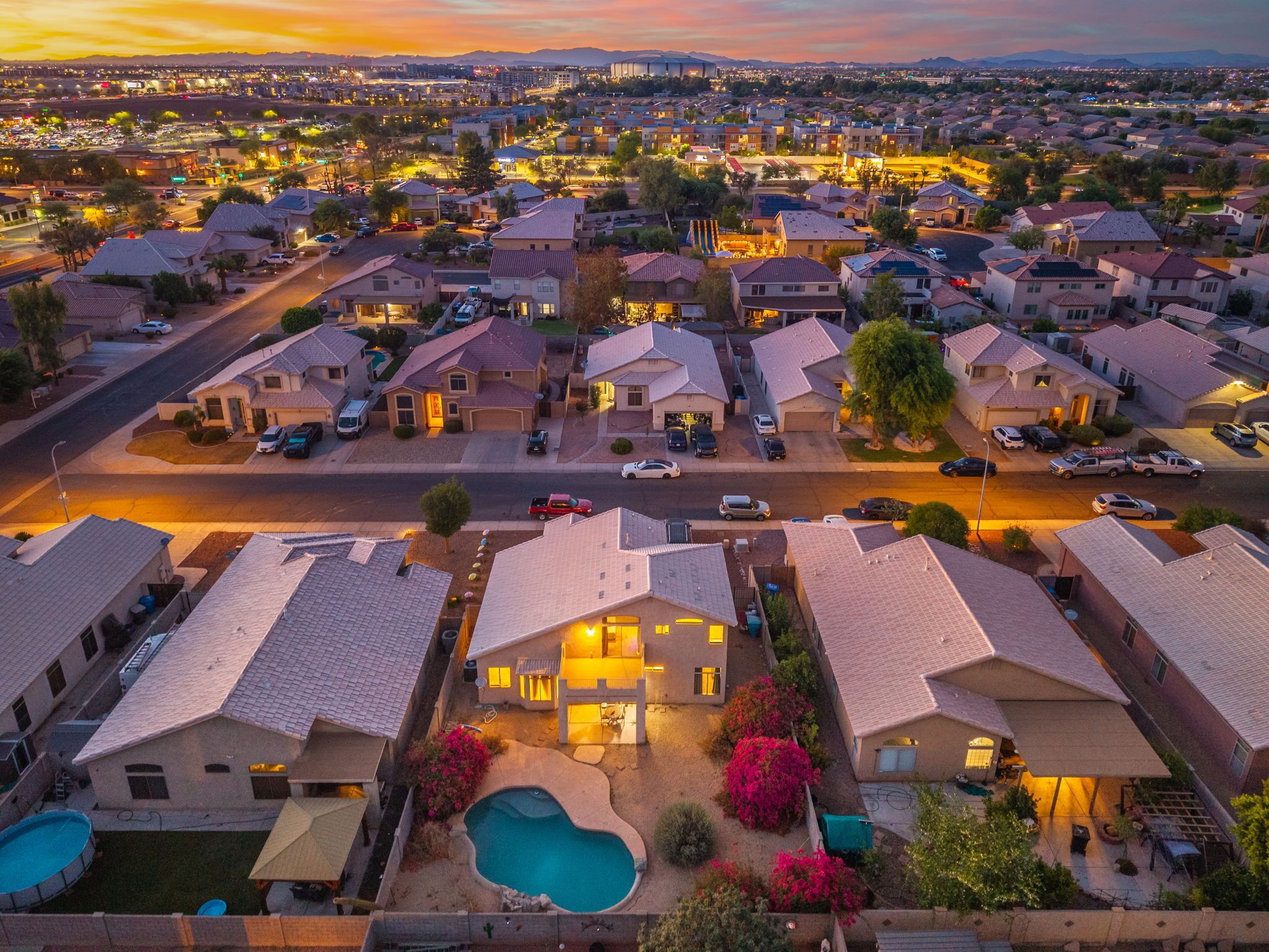 A residential area with houses, a swimming pool, and a road.