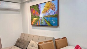 Un salon moderne avec un canapé, une table à manger et un tableau accroché au mur.