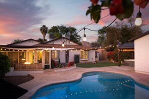 A backyard with a swimming pool, outdoor seating, string lights, and a pergola. - Casa Arcadia Rejuvenation Retreat (Phoenix)