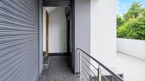 Kapeat, suljetut portaat johtavat parvekkeelle, jossa on metallikaide.
