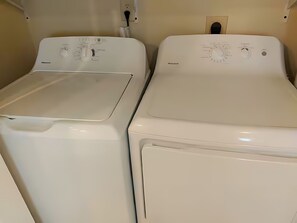 Dos lavadoras blancas de carga frontal en un cuarto de lavandería.