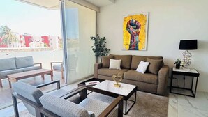 Een moderne woonkamer met een bank, salontafel en een schilderij aan de muur.