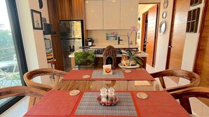 Een moderne keuken met houten kastjes, een centraal eiland en een eethoek met een tafel en stoelen.