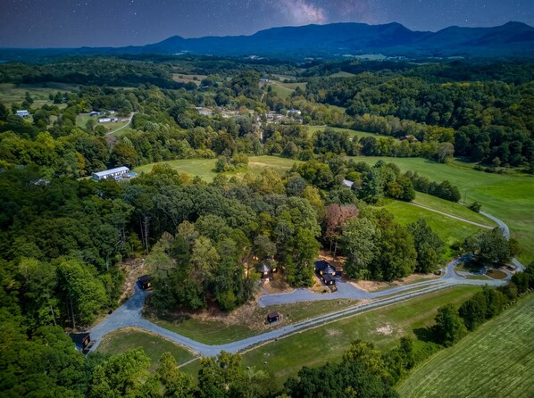 An aerial view of a rural landscape with scattered houses, roads, and a river.