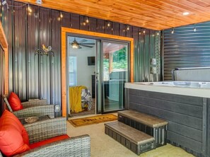 A cozy outdoor seating area with wicker furniture and a wooden ceiling.