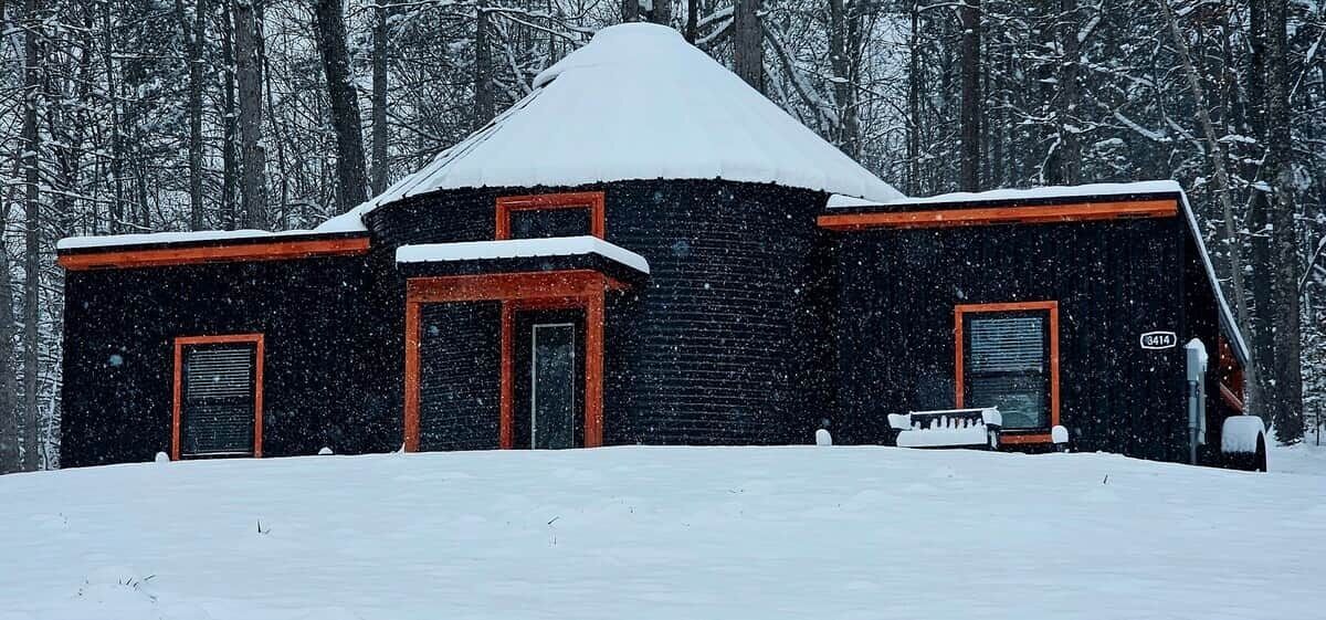 Eine Hütte mit steilem Dach, zwei Türen und einer kleinen Veranda.
