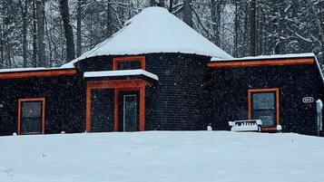 A cabin with a steep roof, two doors, and a small porch.