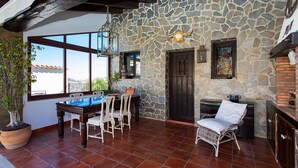 A stone-walled room with a pool table, chairs, a potted plant, and a view through large windows. - CH Villa Aström La Marquesa Golf (Ciudad Quesada)