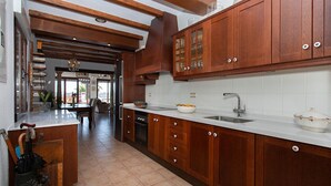 A kitchen with wooden cabinets, a white countertop, and a sink. - CH Villa Aström La Marquesa Golf (Ciudad Quesada)