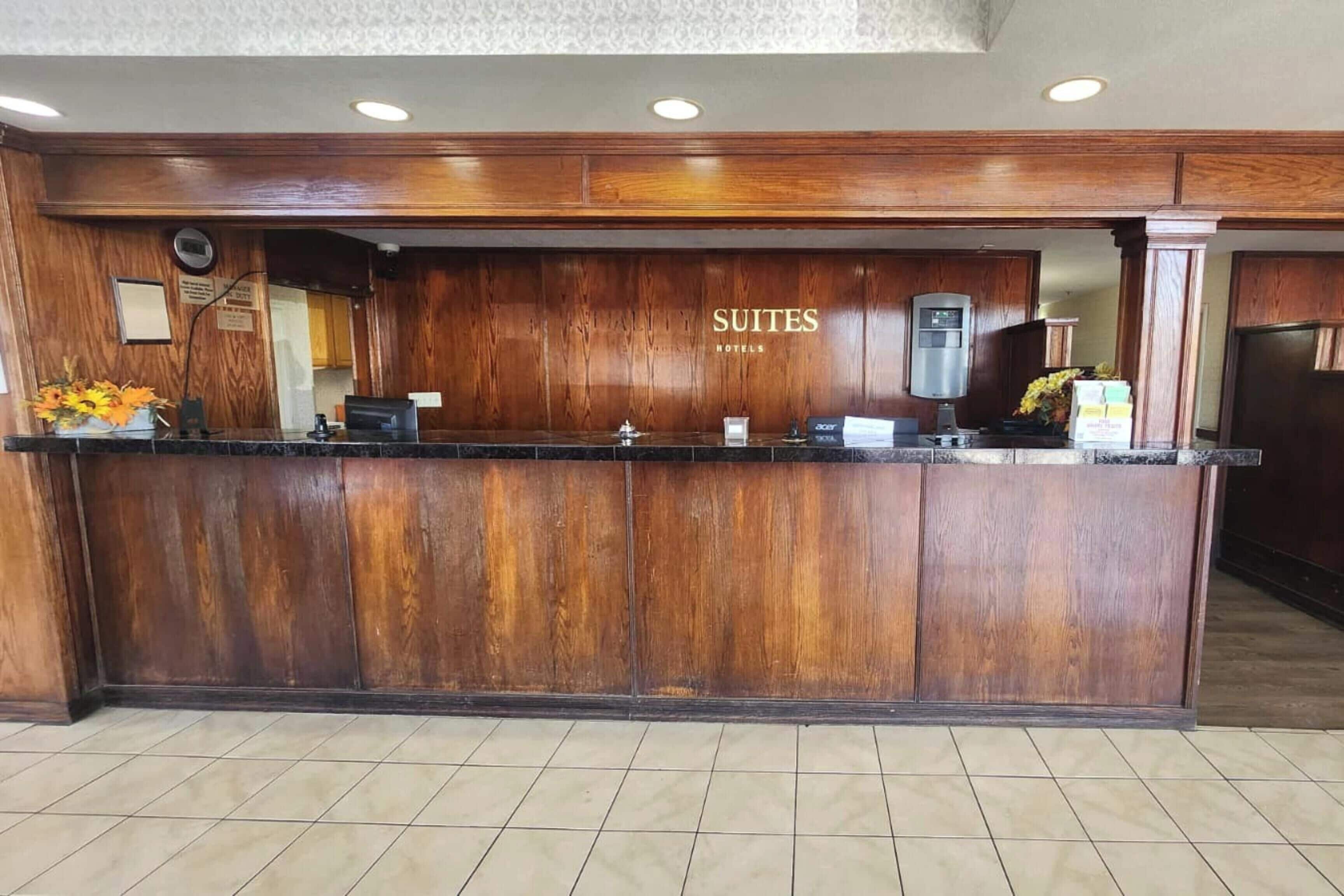 A reception desk with a wooden finish, a digital display, and a water dispenser.