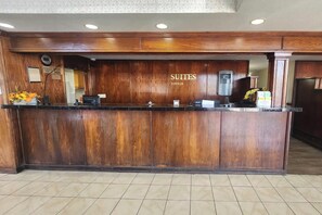 A reception desk with a wooden finish, a digital display, and a water dispenser. - Sunport Suites near Albuquerque Airport I 25 (Albuquerque)