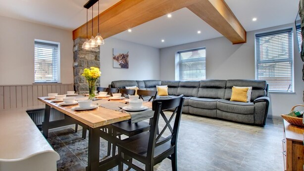 A modern interior with a dining area, a sofa, and a stone accent wall. - 5 Bed in Bala (oc-bow163) (Bala)