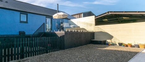 A building with a gravel driveway and a wooden fence.