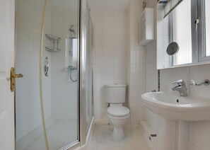 A modern bathroom with a glass shower enclosure, a white toilet, and a sink with a mirror above it. - 3 Bed in Porthleven (oc-rosen) (St Ives)