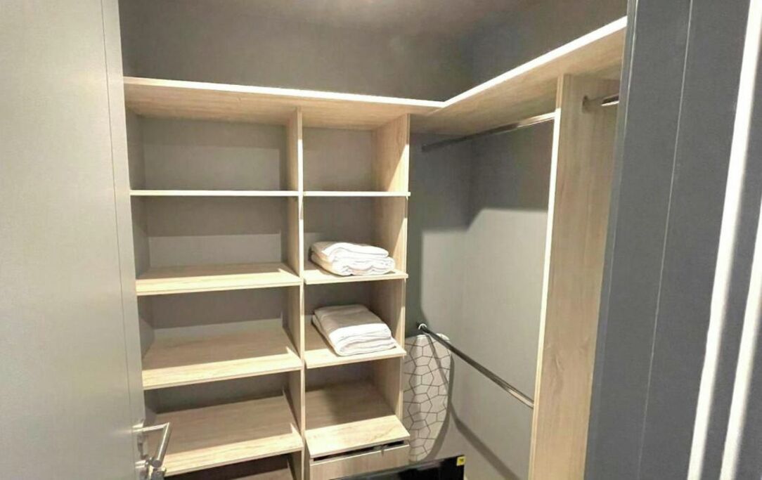Un armario amplio con varias estanterías y una barra para colgar ropa.