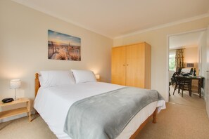 A bedroom with a bed, bedside table, lamp, and a painting on the wall. - 1 Bed in Burnham Market (oc-2193) (Burnham Market)