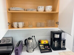 A kitchen with a toaster, kettle, coffee maker, and a drawer with kitchenware. - 2BDRM • 24hrs Security • Top floor with Mountain View • Rooftop Pool and Gym (Kingston)