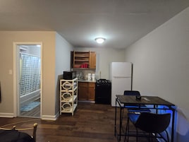 Una cocina compacta con refrigerador, estufa, microondas y gabinetes de madera.
