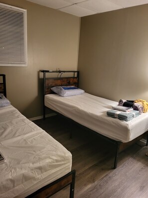 A single bed with a wooden headboard, a pillow, and a blanket on the bed.
