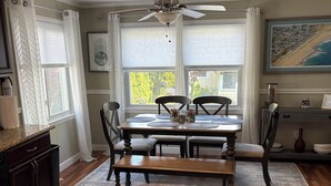 A dining area with a wooden table, chairs, a bench, and a ceiling fan. - 5 bedroom house one block to Sea Girt beach (Sea Girt)