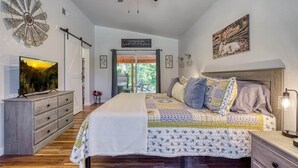Un dormitorio con cama, cómoda y ventilador de techo.