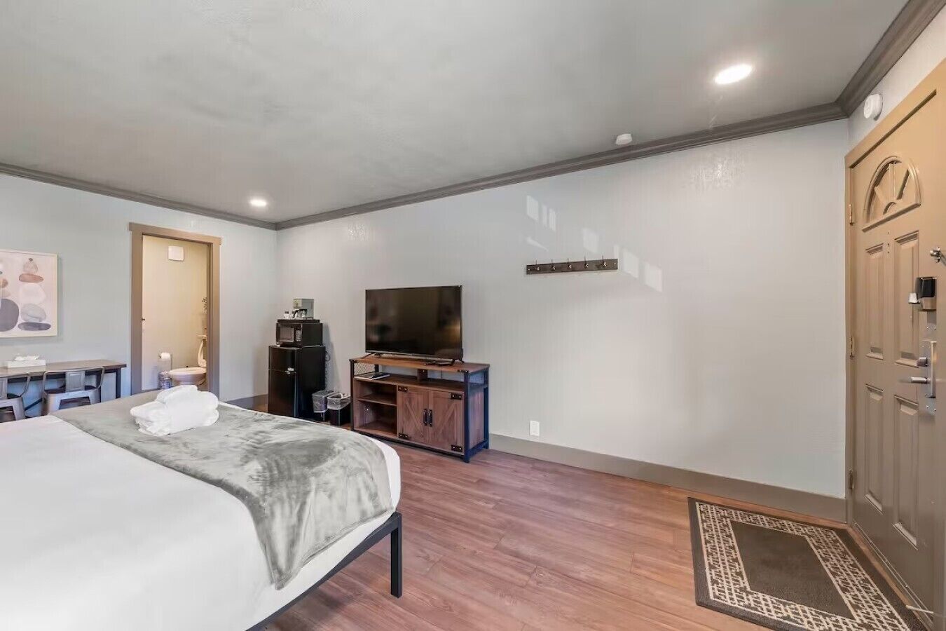 Una habitación de hotel con cama, televisión, escritorio y armario.