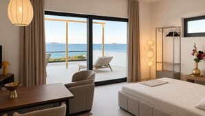 A modern hotel room with a balcony, a bed, a desk, and a chair. - Syros House - Suite: Slow Living by the Sea, Private Terrace, Ocean Views (Azolimnos)