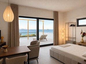 A modern hotel room with a balcony, a bed, a desk, and a chair. - Syros House - Suite: Slow Living by the Sea, Private Terrace, Ocean Views (Azolimnos)