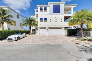 A two-story house with a white exterior, a garage, and a parked white car. - Gulfside Oasis a Dream on the Gulf (Marathon)